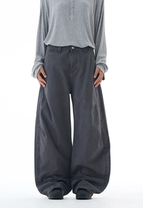 Details einer dunkelgrauen weiten Hose mit geschwungenen Nähten und hochwertigem Stoff