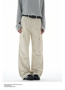 Detail of baggy cargo pants showing beige canvas fabric texture and large side pocket