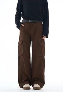 Detail shot of men's dark brown wide-leg cargo pants with large flap pockets and cotton fabric