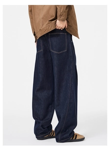Detailed back view of dark blue wide-leg denim jeans with curved seam stitching and side slits