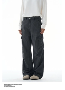 Detailed view of baggy dark grey cargo pants with large side pockets and straight cut