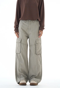 Macro shot of durable cotton cargo pants featuring large utility pockets in olive green