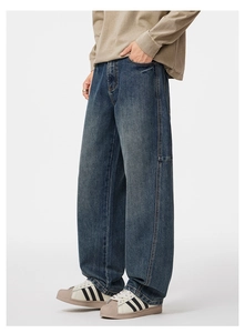 Dettaglio dei jeans a gamba larga con cuciture laterali e texture lavaggio vintage