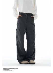 Detail of dark grey baggy cargo pants showing side pockets and smooth seam craftsmanship