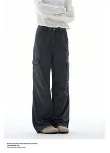 Detail of dark grey baggy cargo jeans featuring large side flap pockets and relaxed cut