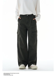 Detail of dark grey multi-pocket cargo pants with washed cotton texture and loose fit