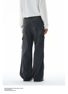 Detail of cargo pockets and washed black fabric texture on baggy retro utility pants