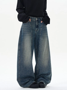 Jean large homme bleu délavé vintage avec coutures apparentes et effet empilé au bas