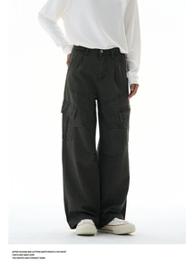 Detail view of large cargo pockets on loose-fit dark olive cotton workwear pants