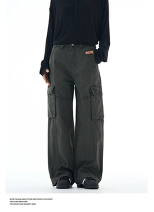 Detail of dark olive cargo pants with side flap pockets and relaxed wide leg cut