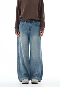 Front detail of retro wide-leg denim jeans with washed effect and slim leather belt