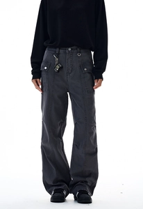 Dettaglio dei pantaloni cargo grigio scuro con gamba larga, tasche e cuciture a contrasto
