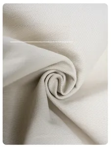 Vista macro del tessuto di cotone twill crema con trama ad alta densità e drappeggio morbido