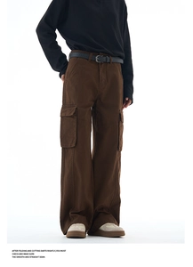 Detail view of brown wide-leg cargo pants with side pockets and a black pin buckle belt