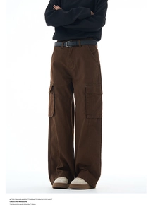 Detail view of deep brown wide-leg cargo pants with large side pockets and cotton fabric