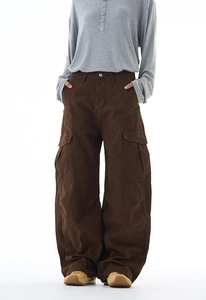 Close-up of oversized brown cargo pants featuring multi-pockets and a wide-leg baggy fit