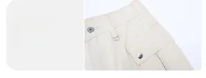 Dettaglio dei pantaloni cargo con vita elastica, anello a D e tasca con bottone a pressione