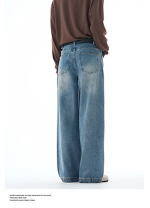 Detail view of mid-blue washed wide leg jeans with loose fit and vintage cat whiskers