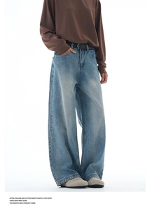 Detailed look at washed blue wide-leg denim jeans with retro whiskering and black belt