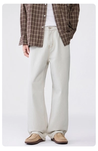 Detailed view of white wide-leg trousers showing orange stitching and metal button details