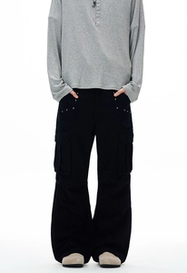 Detail of black cargo pants with flap pockets and silver metal rivets on the side