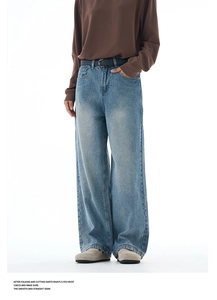 Detail of blue high-waisted wide-leg jeans with washed denim fabric and black belt