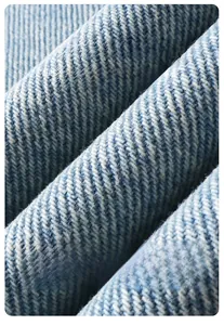 Detailed macro view of light blue twill denim fabric with durable texture and crisp finish