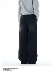 Rear view of loose fit black washed denim jeans showing back pocket stitching details