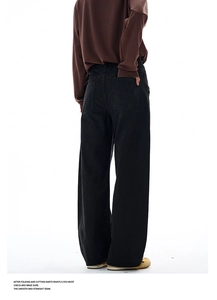 Detail view of black canvas curved leg trousers with oversized back pockets on model