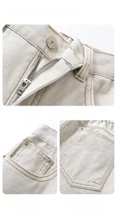 Detail view of denim jeans featuring handmade metal button, zipper, and twill texture