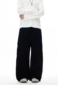 Detail of loose fit black cargo pants featuring functional side pockets and clean stitching