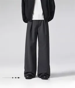 Detail showing the loose straight fit and premium drape of dark grey wool trousers