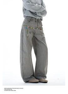 Detailed view of colorful floral embroidery on high-waisted dark grey cargo pants