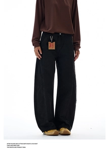 Detail view of black wide-leg trousers with curved seams and vintage workwear design