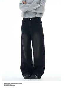 Detail of high-waisted black washed denim pants with metal button and pocket stitching