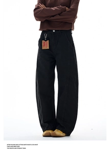 Close-up of black wide-leg trousers featuring a vintage curved silhouette and brand tag