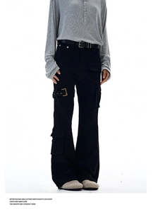 Macro detail of black cargo trousers featuring side utility pocket and metal buckle straps