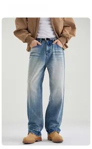 Detail of light blue straight-leg denim jeans with vintage whiskering and stone wash texture