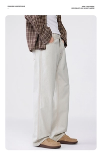 Close-up of minimalist cream white wide-leg trousers with contrast yellow stitching detail
