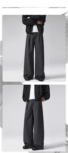 Detailed view of dark grey wide-leg trousers with front pleats and heavy wool texture