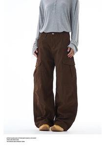 Detail of dark brown cargo pants featuring large side pockets and a wide-leg baggy fit