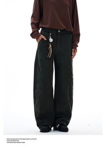 Detail of dark grey curved-seam canvas pants with vintage leather tassel keychain