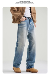 Detail of light blue loose fit straight jeans featuring washed cat whiskers and drape texture
