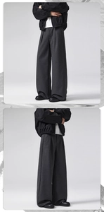 Detail of dark grey wool dress pants featuring front pleats and a wide-leg drape style