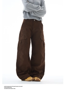 Detail of dark brown cargo pants featuring wide-leg cut and large side flap pockets