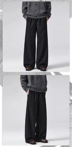 Detailed close-up of men's wide-leg wool trousers featuring a relaxed straight-cut silhouette