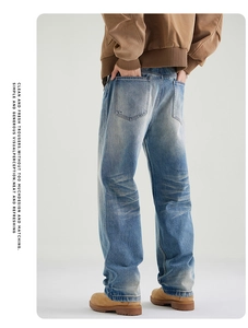 Detail view of light blue washed straight-leg jeans with vintage cat whiskers texture