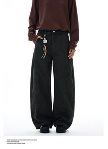 Detail showing smooth flat seams and silver metal charm on dark green cargo pants
