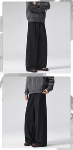 Detail of wide-leg black wool trousers with elegant drape and pleated texture