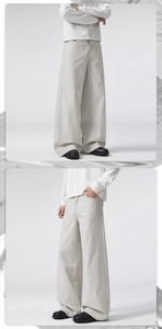 Detail showing the heavy drape and texture of wide-leg cotton trousers in off-white